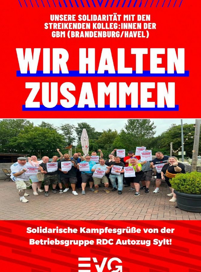 Plakat mit rotem Hintergrund. Oben steht: „UNSERE SOLIDARITÄT MIT DEN STREIKENDEN KOLLEG:INNEN DER GBM (BRANDENBURG/HAVEL)“. Darunter in sehr großer weißer Schrift: „WIR HALTEN ZUSAMMEN“. Im mittleren Bereich Gruppenfoto im Freien auf einer gepflasterten Fläche mit etwa 15 Personen, die Papierplakate hochhalten. Im Hintergrund sind Bäume, ein geschlossener Sonnenschirm und Außenbereich-Mobiliar zu sehen. Unten steht: „Solidarische Kampfesgrüße von der Betriebsgruppe RDC Autozug Sylt!“ sowie das EVG-Logo.