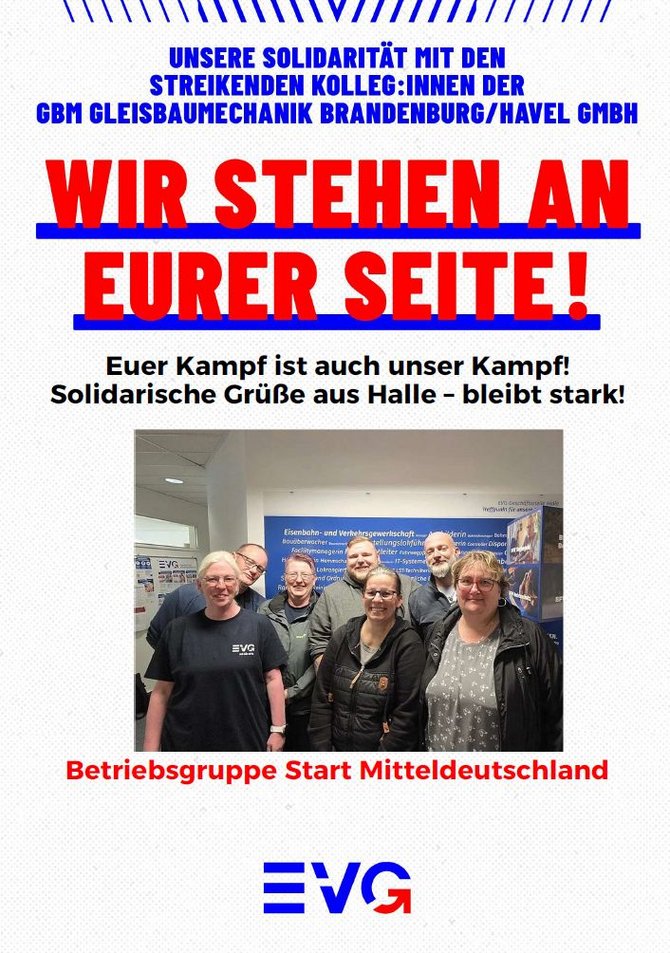 Plakat mit weißem Hintergrund und blau-roten Gestaltungselementen. Oben steht in blauer Schrift: „UNSERE SOLIDARITÄT MIT DEN STREIKENDEN KOLLEG:INNEN DER GBM GLEISBAUMECHANIK BRANDENBURG/HAVEL GMBH“. Darunter in sehr großer roter Schrift mit blauer Unterstreichung: „WIR STEHEN AN EURER SEITE!“. Darunter in schwarzer Schrift: „Euer Kampf ist auch unser Kampf! Solidarische Grüße aus Halle – bleibt stark!“. Im unteren Mittelteil befindet sich ein Gruppenfoto von sieben Personen in einem Innenraum vor einer Informationswand mit EVG-Logo und Texten. Unter dem Foto steht in roter Schrift: „Betriebsgruppe Start Mitteldeutschland“. Am unteren Rand ist das blaue EVG-Logo mit rotem Bogen abgebildet. Oben und unten befinden sich dekorative blaue Linien.